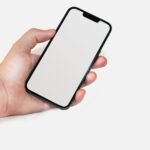 a hand holding an iphone with a blank screen