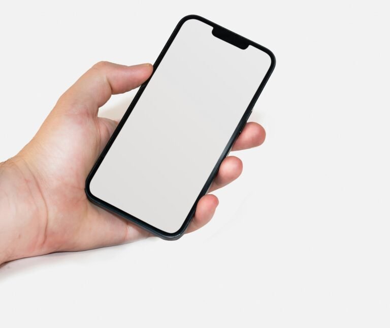 a hand holding an iphone with a blank screen